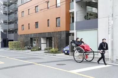 two people riding a rickshaw on a city street at Asakusa 501 Quad room in Tokyo