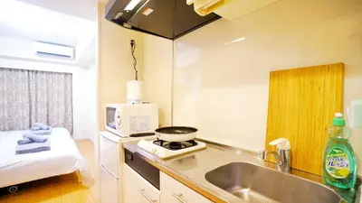 a kitchen with a sink and a stove in a room at Shinjuku-IEE in Tokyo