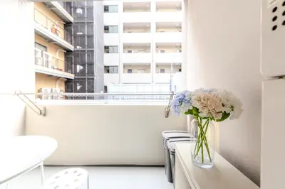 a vase of flowers sitting on a table in front of a window at Shinjuku-IEE in Tokyo