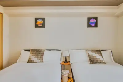 two beds sitting next to each other in a room at Shinjuku-IEE in Tokyo