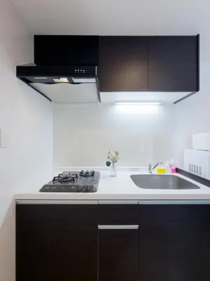 a white kitchen with a sink and a stove at Asakusa 302 Triple Room in Tokyo