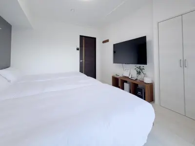 a bedroom with a white bed and a flat screen tv at Asakusa 302 Triple Room in Tokyo