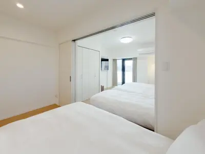 a bedroom with two beds and a mirror at Asakusa 201 Quad room in Tokyo