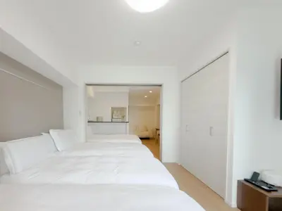a bedroom with white walls and white beds at Asakusa 201 Quad room in Tokyo