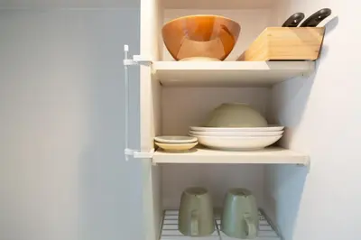a shelf with bowls and other kitchen utensils at Ikebukuro Twin Room in Tokyo