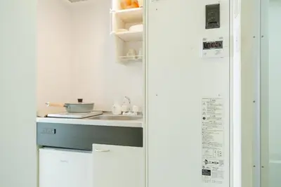 a white kitchen with a sink and a counter at Ikebukuro Twin Room in Tokyo
