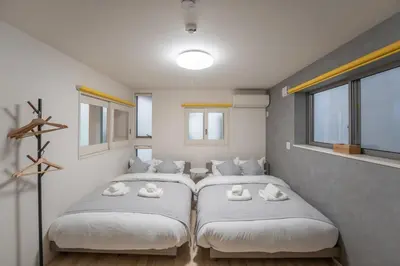 two beds in a room with white pillows at \u6075\u6bd4\u5bff\u99c5\u5f92\u6b695\u5206 \u8cb8\u5207\u4e00\u8ed2\u5bb6 in Tokyo