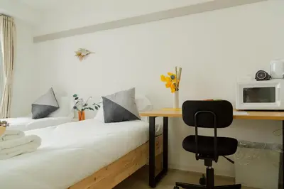 two beds in a room with a desk and a microwave at Ikebukuro 507 Twin Room in Tokyo