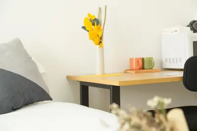 a vase of flowers on a table next to a bed at Ikebukuro 507 Twin Room in Tokyo