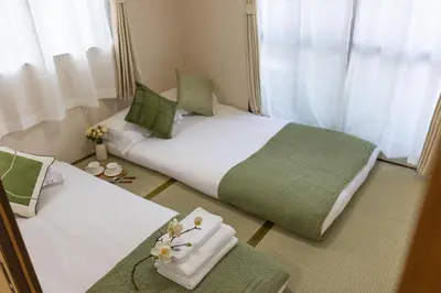 two beds in a hotel room with flowers on them at Near skytree direct ueno asakusa,,baby bed,baby chair in Tokyo