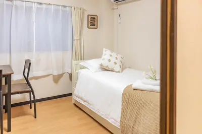 a bedroom with a bed and a table and a window at Near skytree direct ueno asakusa,,baby bed,baby chair in Tokyo