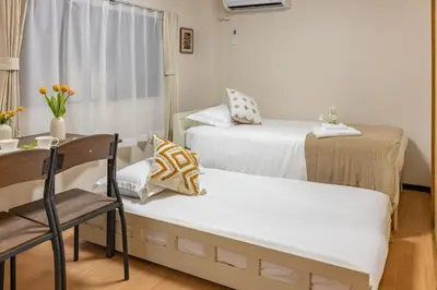 a room with two beds and a chair and a table at Near skytree direct ueno asakusa,,baby bed,baby chair in Tokyo