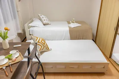 a small room with two beds and a table at Near skytree direct ueno asakusa,,baby bed,baby chair in Tokyo