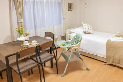 a small room with a dining table and a bed at Near skytree direct ueno asakusa,,baby bed,baby chair in Tokyo
