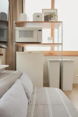 a bedroom with a microwave on a shelf at Ikeda Ueno 301 Twin Room in Tokyo