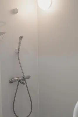 a shower with a hose attached to a wall at Ikeda Ueno 301 Twin Room in Tokyo