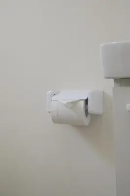 a white toilet paper dispenser on a wall at Ikeda Ueno 301 Twin Room in Tokyo