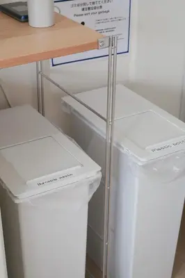 a white refrigerator and two trash cans next to a table at Ikeda Ueno 301 Twin Room in Tokyo