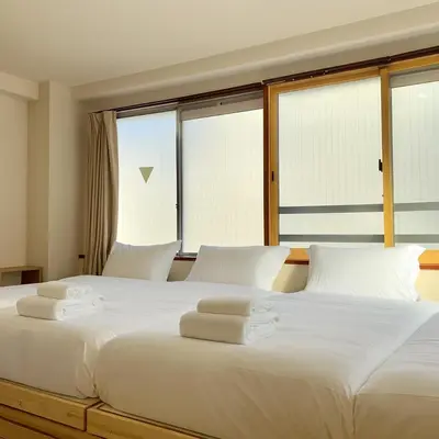 a large white bed with towels on top of it at Ikeda Ueno 401 Quad room in Tokyo