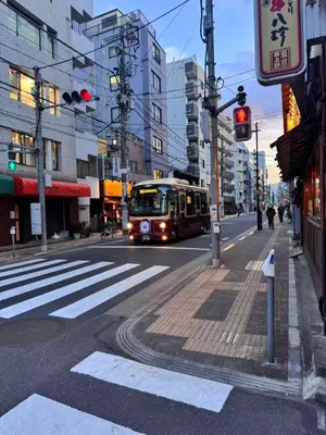 a bus is driving down a city street at Ikeda Ueno 401 Quad room in Tokyo