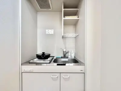 a small kitchen with a sink and a stove at Ikeda Ueno 501 Quad room Room in Tokyo