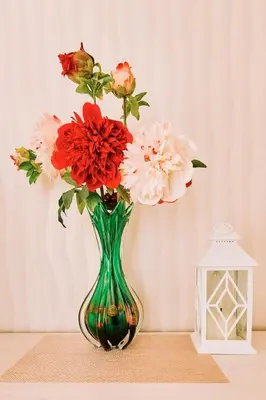 a green vase with red and white flowers in it at \u697d\u697d\u6c11\u6cca in Tokyo