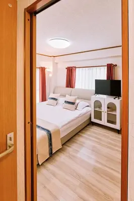 a bedroom with a large bed and a television at \u697d\u697d\u6c11\u6cca in Tokyo