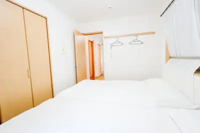a white bedroom with two beds and a closet at T akadababa subway 4 mins walk! Newly building \u65b0\u7bc9! \u9ad8\u7530\u99ac\u5834\u99c5 \u5f92\u6b69\u570f\u5185\u5927\u4eba\u6c17! Shinjuku\u65b0\u5bbf\u5708!\u9ad8\u901f\u65e0\u9650\u5236202 in Tokyo
