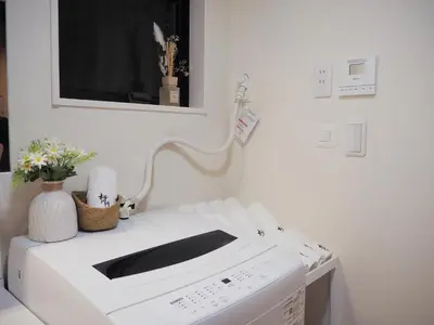 a white washing machine in a room with flowers at \u685c\u306e\u5ddd67 \u6e0b\u8c37\u533a\u4e28\u65b0\u5bbf\u307e\u3067\u4e00\u99c5 2-10\u4eba\u4e28Shibuya One stop to Shinjuku 2-10 people in Tokyo
