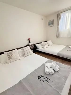two beds sitting in a room with a rug on the floor at \u685c\u306e\u5ddd67 \u6e0b\u8c37\u533a\u4e28\u65b0\u5bbf\u307e\u3067\u4e00\u99c5 2-10\u4eba\u4e28Shibuya One stop to Shinjuku 2-10 people in Tokyo