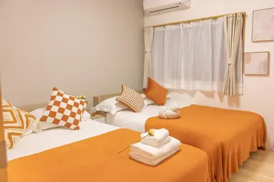 a room with two beds with orange and white sheets at Near Shinjuku,3LDK Mansion,3bedrooms,12 people in Tokyo
