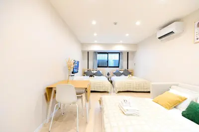 a living room with two beds and a table at Mi-HOTEL UENO in Tokyo
