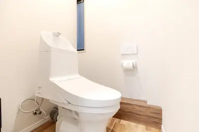 a bathroom with a toilet with a blue stripe on the wall at Mi-HOTEL UENO in Tokyo