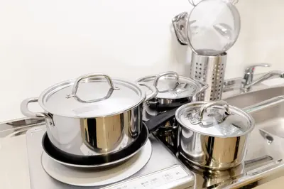 three pots and pans sitting on top of a stove at Mi-HOTEL UENO in Tokyo