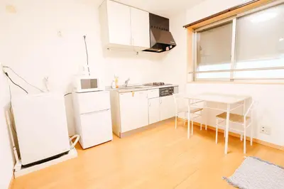 a kitchen with a white refrigerator and a table at t akadababa subway 4 mins walk! Newly building \u65b0\u7bc9! \u9ad8\u7530\u99ac\u5834\u99c5 \u5f92\u6b69\u570f\u5185\u5927\u4eba\u6c17! Shinjuku\u65b0\u5bbf\u5708!\u9ad8\u901f\u65e0\u9650\u5236301 in Tokyo