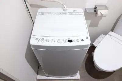 a white toilet in a bathroom next to a toilet paper dispenser at \u30aa\u30fc\u30af\u30ec\u30b9\u30c8\u6075\u6bd4\u5bff in Tokyo