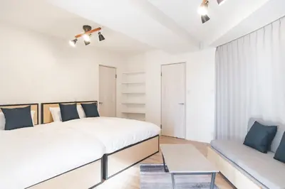 a white bedroom with a bed and a couch at DeLCCS\u8981\u753a in Tokyo