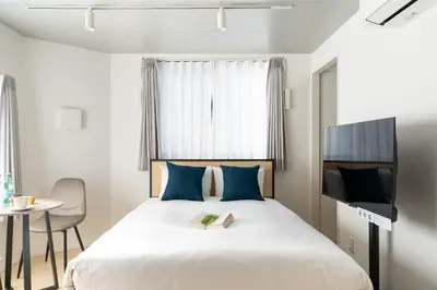 a bedroom with a bed with a book and a tv at Bel Avenir in Tokyo