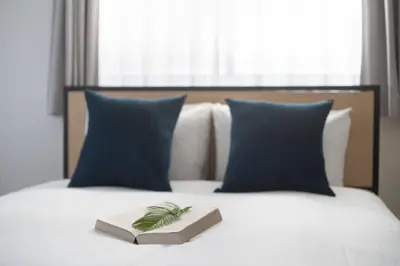 a book sitting on top of a bed with pillows at Bel Avenir in Tokyo