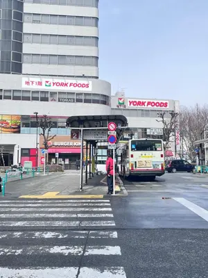 a person is standing at a bus stop at a street at ToyamaHouse2-203 in Tokyo