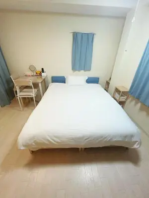 a large white bed in a room with a table at ToyamaHouse2-203 in Tokyo