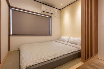 a small bedroom with a bed and a large window at \u826f\u5c45\u6c11\u5bbf YOSHII House \u6674\u7a7a\u5854\u5f92\u6b65\u5708 \u6574\u680b\u51fa\u79df in Tokyo