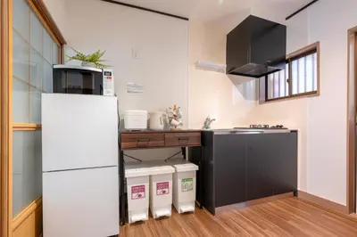 a kitchen with a white refrigerator and a microwave at \u826f\u5c45\u6c11\u5bbf YOSHII House \u6674\u7a7a\u5854\u5f92\u6b65\u5708 \u6574\u680b\u51fa\u79df in Tokyo