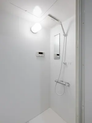 a white bathroom with a shower and a mirror at \u826f\u5c45\u6c11\u5bbf YOSHII House \u6674\u7a7a\u5854\u5f92\u6b65\u5708 \u6574\u680b\u51fa\u79df in Tokyo