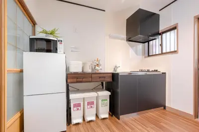 a kitchen with a white refrigerator and a sink at \u826f\u5c45\u6c11\u5bbf YOSHII House \u6674\u7a7a\u5854\u5f92\u6b65\u5708 \u6574\u680b\u51fa\u79df in Tokyo