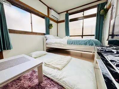 two beds in a room with windows at \u6c60\u888b\u99c5\u5f92\u6b69OK \u65b0\u5bbf\u99c524\u5206 \u6771\u4eac\u306e\u89b3\u5149\u540d\u6240\u3078\u306e\u30a2\u30af\u30bb\u30b9\u826f\u597d NINJA\u5c4b\u6577\u306e\u6587\u5316\u4f53\u9a131k in Tokyo