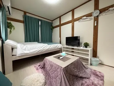 a bedroom with a bed and a tv and a table at \u6c60\u888b\u99c5\u5f92\u6b69OK \u65b0\u5bbf\u99c524\u5206 \u6771\u4eac\u306e\u89b3\u5149\u540d\u6240\u3078\u306e\u30a2\u30af\u30bb\u30b9\u826f\u597d NINJA\u5c4b\u6577\u306e\u6587\u5316\u4f53\u9a131k in Tokyo