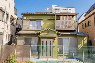 a green house with a fence in front of it at Mori house\u738b\u5b50\u672c\u753a in Tokyo