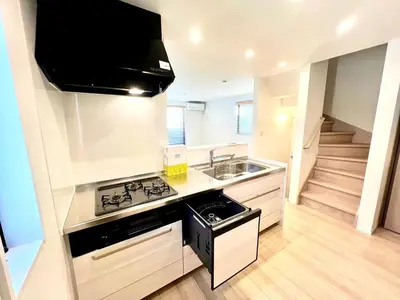 a kitchen with a stove and a sink and a staircase at Ochiai Open House in Tokyo