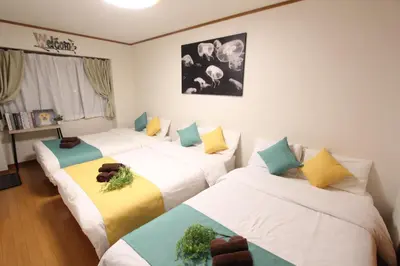 three beds in a room with white and blue at HOTEL LUANA in NISHIKI in Tokyo